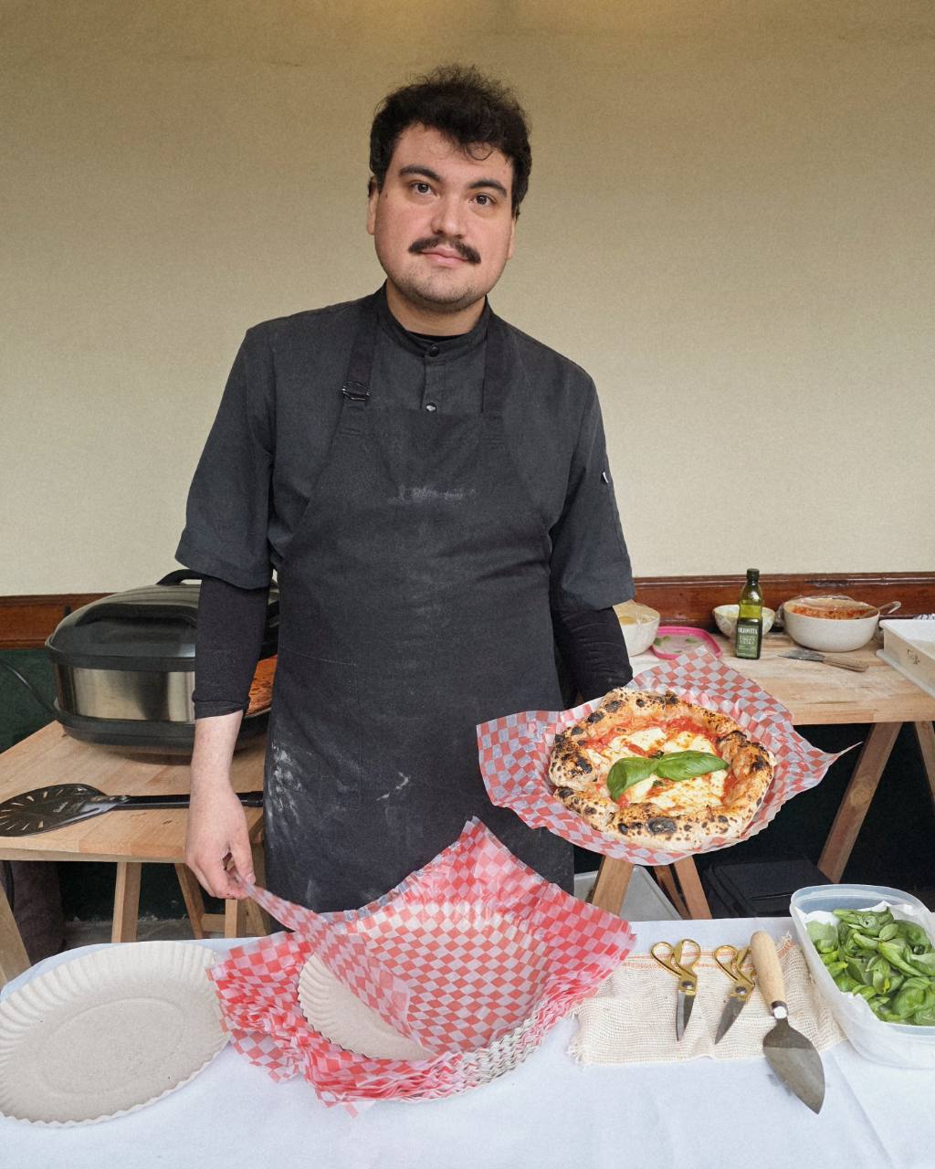 Emmanuel Vallejo, fundador y pizzaiolo de Connie Pizza al Forno, presentando una pizza.