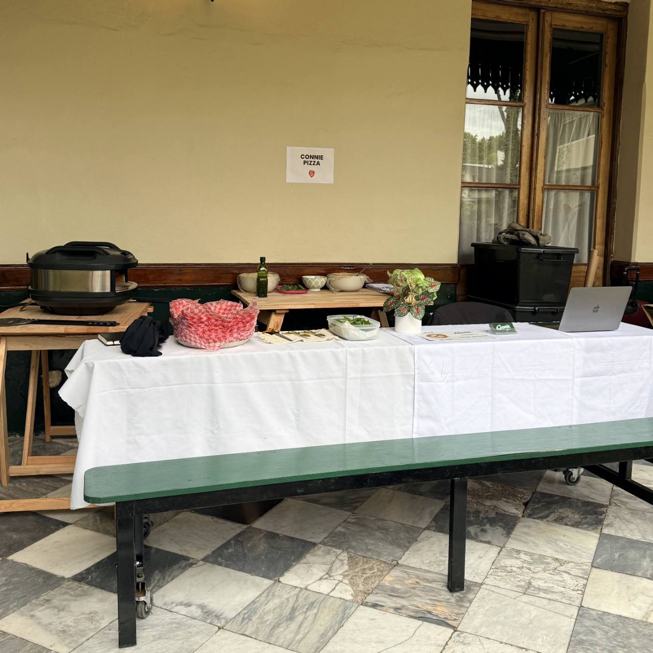 Estación de Connie Pizza al Forno instalada para un evento, con horno y mesa de preparación.