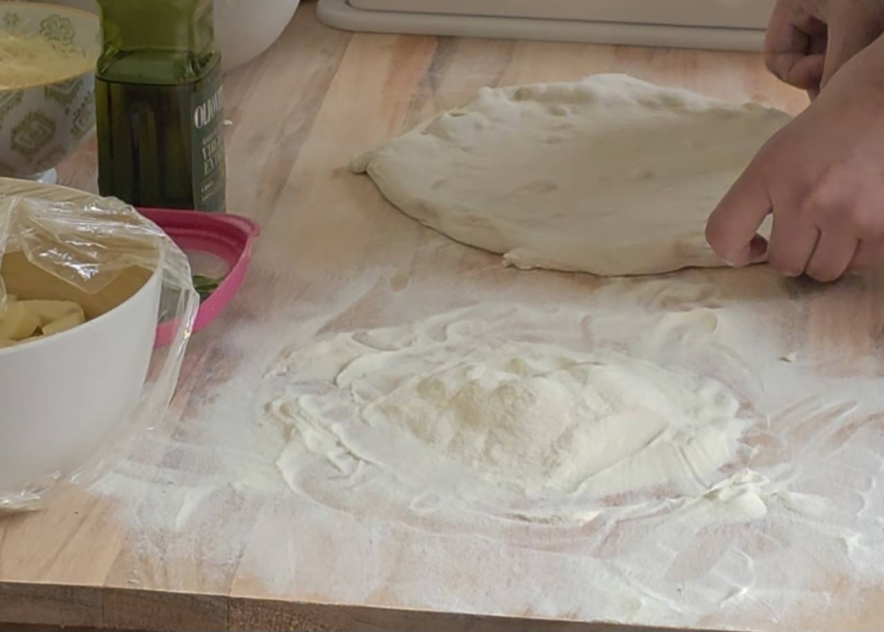 Estirado a mano de la masa sobre la mesa de preparación de Connie.