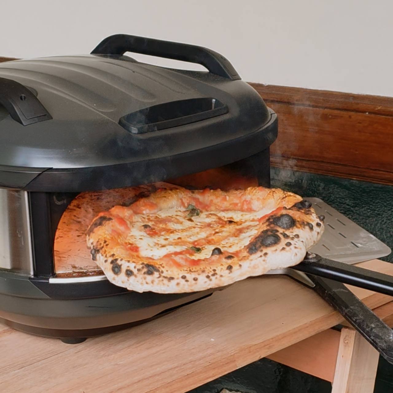 Pizza recién horneada sobre una pala frente al horno de Connie Pizza al Forno.